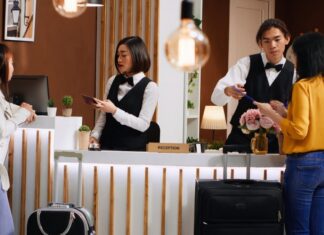 Women going through registration process at hotel front desk